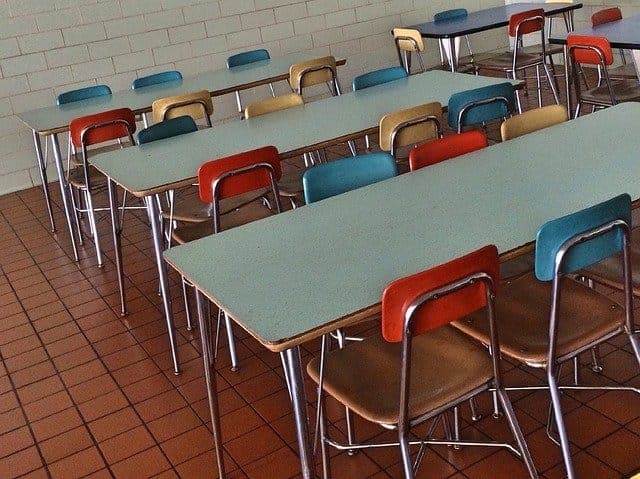 Rows of empty desks and chairs in a classroom